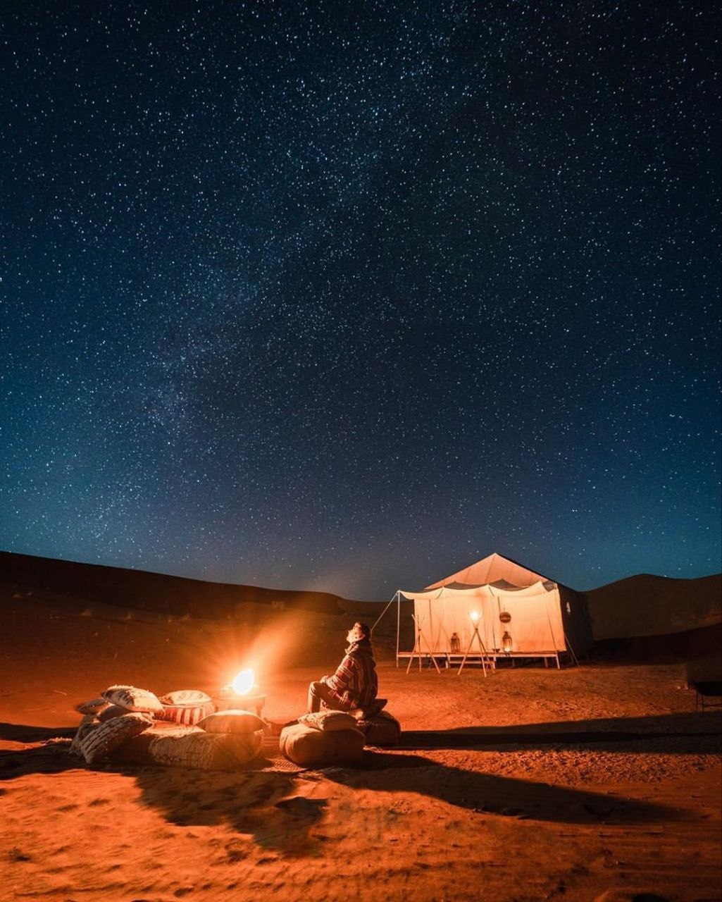 Traditional Berber desert camp with fire and musicians at night